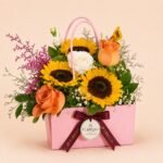 Sunflower and rose arrangement in a pink handbag flower box