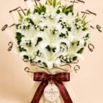 Grand white lily bouquet with baby's breath and ivory wrapping