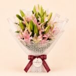 Premium pink lily bouquet with many fresh buds in white mesh wrapping
